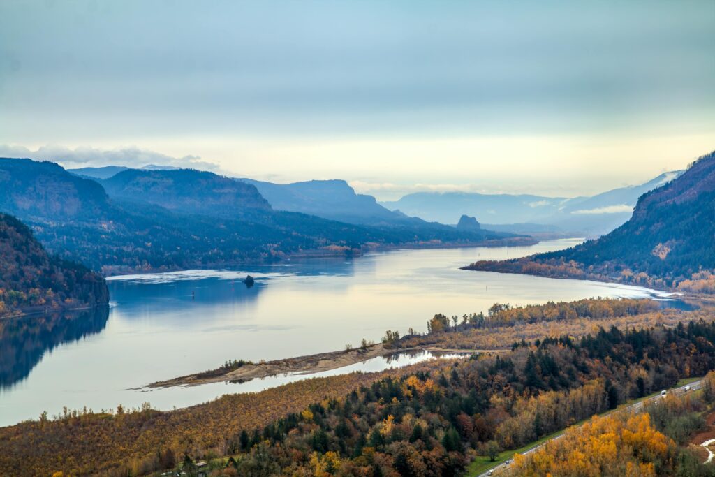 Scenic river valley with cliffs and forested hills in the Pacific Northwest.